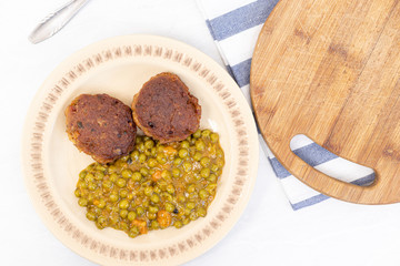 Served fried meatballs with cooked peas on the plate