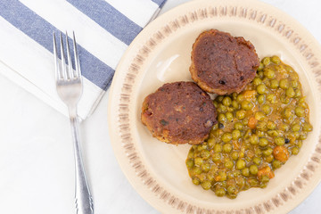 Served fried meatballs with cooked peas on the plate