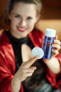 elegant woman showing makeup remover with cotton pads