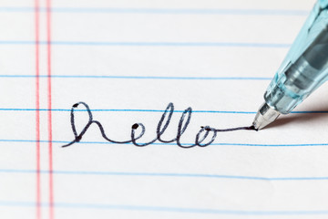 Writing the word hello with a pen on paper - 344337548