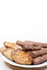Mixed grilled meat on the plate. Grilled kebabs and pork chops served on the plate with copy space