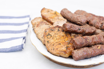 Mixed grilled meat on the plate. Grilled kebabs and pork chops served on the plate