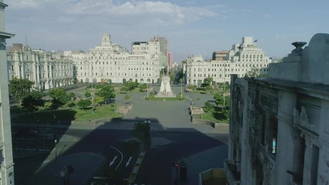 Dolly in with drone from avenida la colmena, between buildings to plaza San Martin.