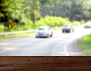 Empty wood table top on Asphalt road through the forest, blur natural background. For montage product display