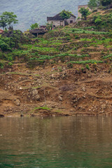 Wuchan, China - May 7, 2010: Dragon Gate Gorge on Daning River. Farm house above terraced...