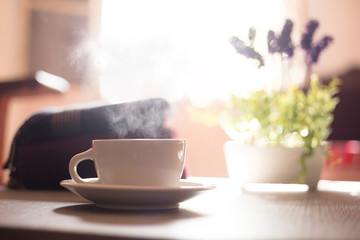 Close-up of a hot beverage over a table with a plant and sweater behind it