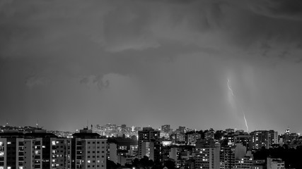 Imagens da chegada de uma tempestade de verão com raios e chuva, na cidade durante a noite em...