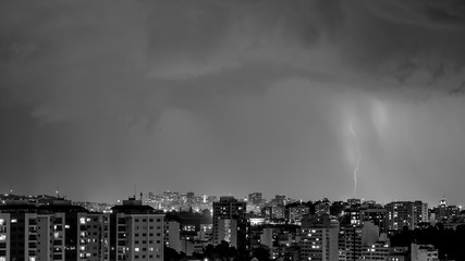 Imagens da chegada de uma tempestade de verão com raios e chuva, na cidade durante a noite em...