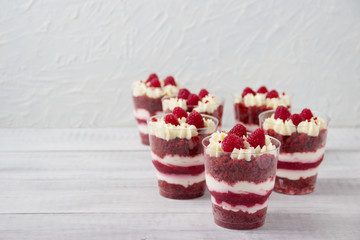 Delicious dessert in a glass, with raspberry jelly, cream and  fresh raspberries. Dessert for lovers.