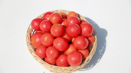 Top view of basket of fresh ripe tomatoes on white background, organic food