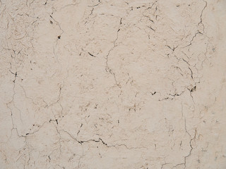 Beige stucco wall crackle surface. Light beige textured background. Grunge texture.
