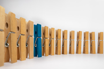 Conceptual composition of clothespins simulating a man standing out in a row of people.