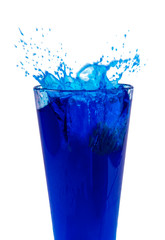 Blue cocktail or water splashes in glass isolated on the white