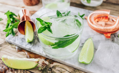 Lemonade, infused water or Mojito cocktail making. Mint, lime, ice ingredients and bar utensils.