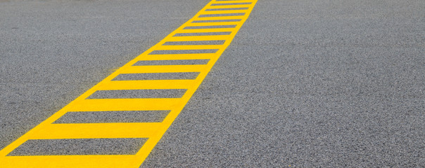 yellow lines on asphalt showing a safe crossing