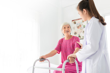 Fototapeta premium close up old patient, asian doctor talk about treatment process, walk training and rehabilitation process, old stroke patient uses walker with doctor in hospital, elderly healthcare promotion