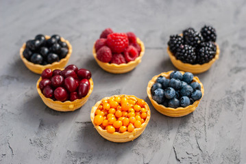 Homemade tartlets from shortcrust pastry with different ripe berries