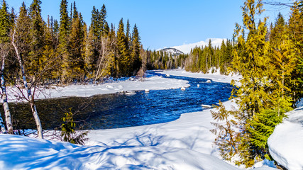 Snow and ice lining the Murtle River in winter time in the Cariboo Mountains of Wells Gray...