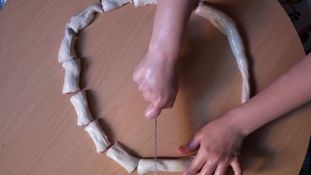 Top view of woman hands cutting the manti or patty or borek turkish style food with knife