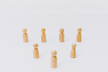 Social distance symbolized with wooden figures isolated from each other on white background.