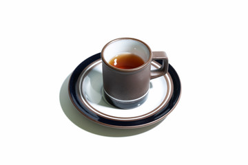Black tea in purple clay & ceramic tea cup set with plate isolated on white background. Macro. Close-up.
