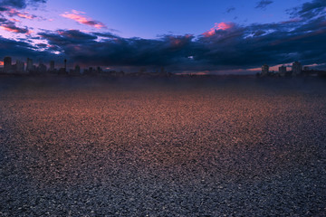 Asphalt road at sunset with city background. Empty asphalt highway and building with nice sky clouds.
