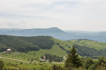Fototapeta na wymiar Mountain landscape with green slopes, mountains and sky on background.