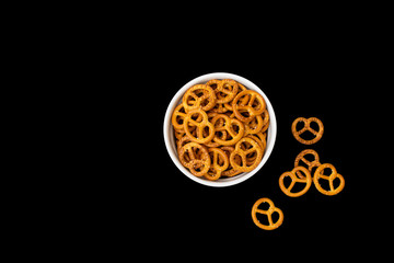 Pretzels in a white bowl with isolated black background
