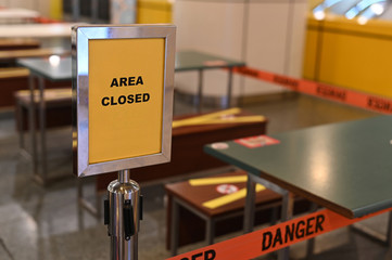 An outdoor eatery placed a yellow closed sign for a pandemic lockdown period