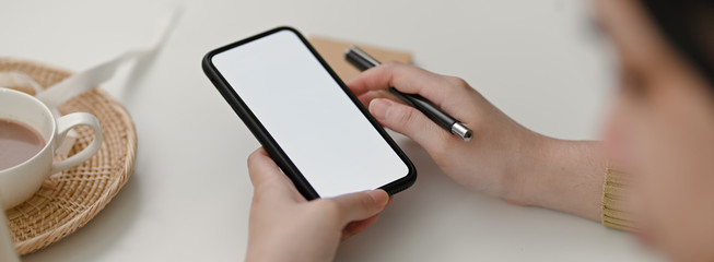 Close up view of female freelancer using mock-up smartphone to contact customer
