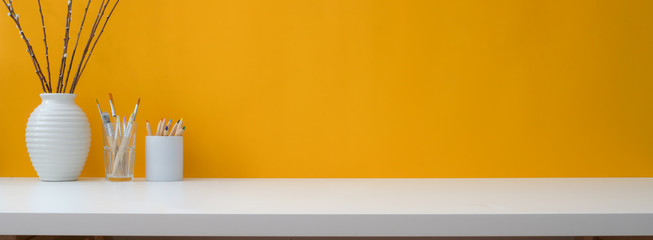 Close up view of creative workspace with decorations, painting tools and copy space