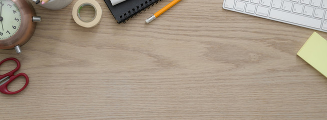 Overhead shot of comfortable workspace with computer devices,  supplies, decoration and copy space
