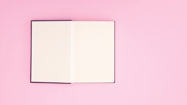Purple book appear and opens on first page on pink background - Stop motion 