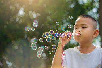 Asian little boy is blowing a soap bubbles