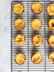 Fresh baked Portuguese Egg Custard Tarts, Pasteis De Nata, on a cooling rack 