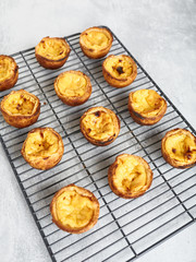 Fresh baked Portuguese Egg Custard Tarts, Pasteis De Nata, on a cooling rack 