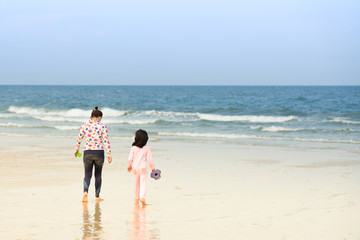 Fototapeta na wymiar people stand on beach front at coast line on blue sky background
