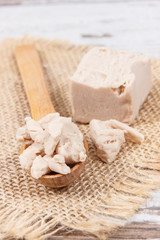 Fresh crumbled yeast on spoon for baking different dough or bread