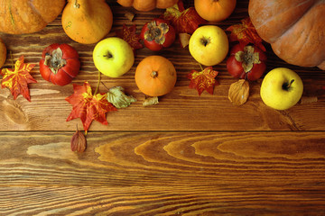 A bunch of pumpkins and apples. Harvest or Thanksgiving background with autumnal fruits and gourds on rustic wooden table. - Powered by Adobe