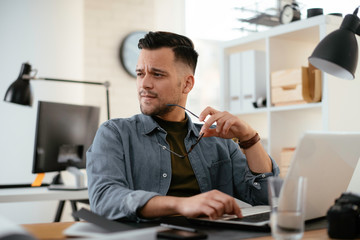Businessman in office. Handsome man working on lap top.