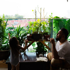 Bangi, Malaysia - April 16, 2020: Father playing soap bubbles with child at home. Stay home during lockdown due to Coronavirus, Covid 19 outbreak. Selective focus.