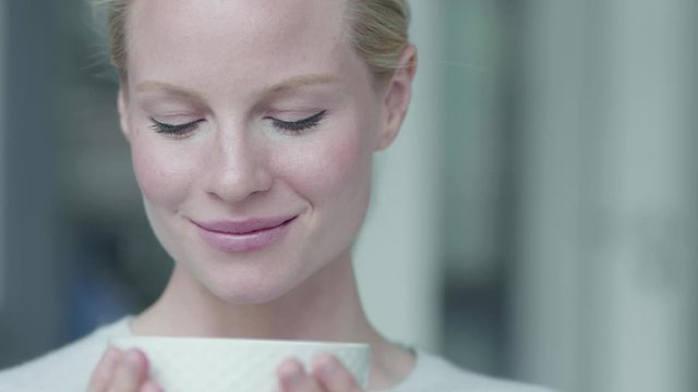 Blond woman drinking cup of tea