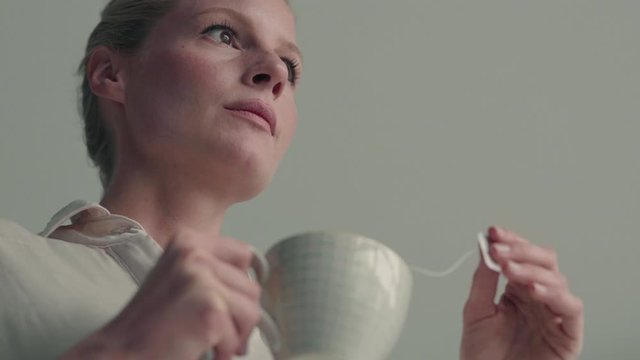 Low-angle shot of woman with cup of tea and teabag