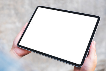 Top view mockup image of a woman holding a black tablet pc with blank white screen in the outdoors street background