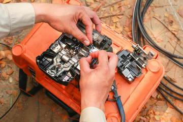 The technician is connecting the fiber optic cable 