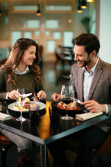 Happy loving couple enjoying in restaurant. Young couple enjoying in food.	