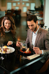 Happy loving couple enjoying in restaurant. Young couple enjoying in food.	
