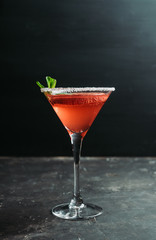 Red cocktail with bloody oranges in martini glass on the rustic background. Selective focus. Shallow depth of field.