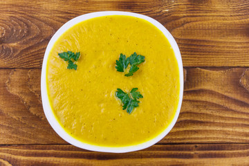 Pumpkin soup on a wooden table. Top view