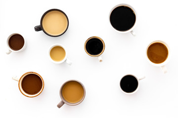 Cups of hot drinks on white desk top view